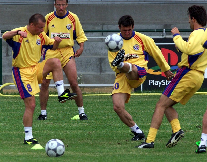 BR005 - 20000615 - MEISE, BELGIUM : Romanian Gheorghe Hagi (C) kicks the ball durin a training with his team colleague Dorinel Ionel Munteanu (L) and Ovidiu Stinga (back second left) at the Meise stadium on Tuesday 15 June 2000 prior the EURO 2000 second match against Portugal this Saturday. EPA PHOTO BELGA/PASCAL GEORGES/bb