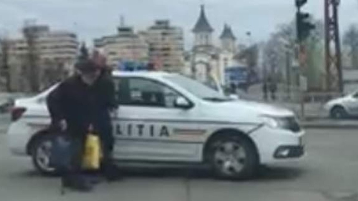Un polițist a oprit traficul într-o intersecție aglomerată pentru a ajuta un bătrân să traverseze