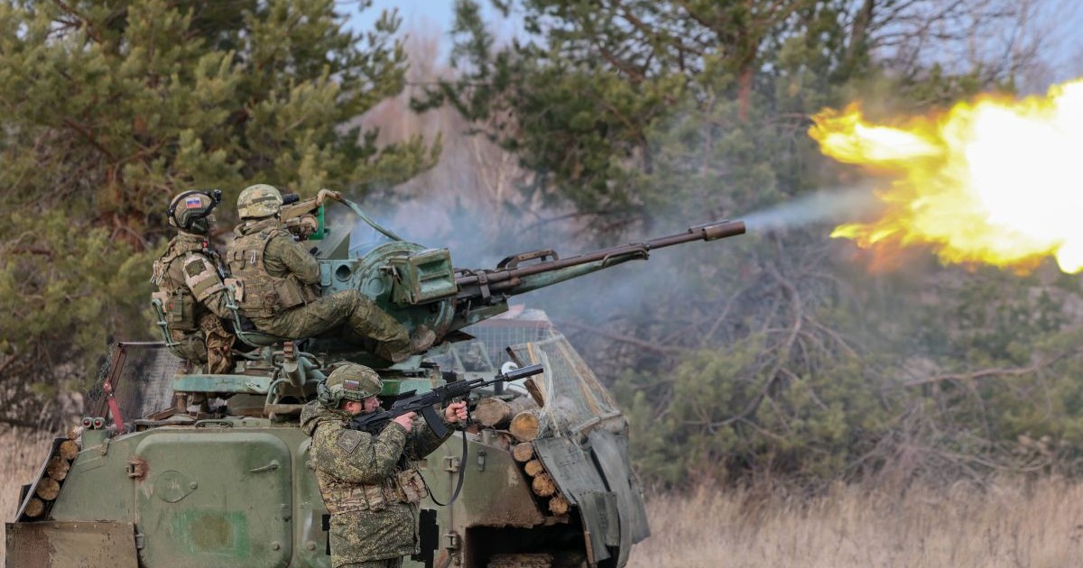 Doi soldați ruși operează un tun antiaerian ZU-23-2 cu două țevi, montat pe un blindat de luptă pe șenile MT-LB, în timp ce un al treilea militar stă lângă vehicul și trage cu o armă automată, 2 martie 2026