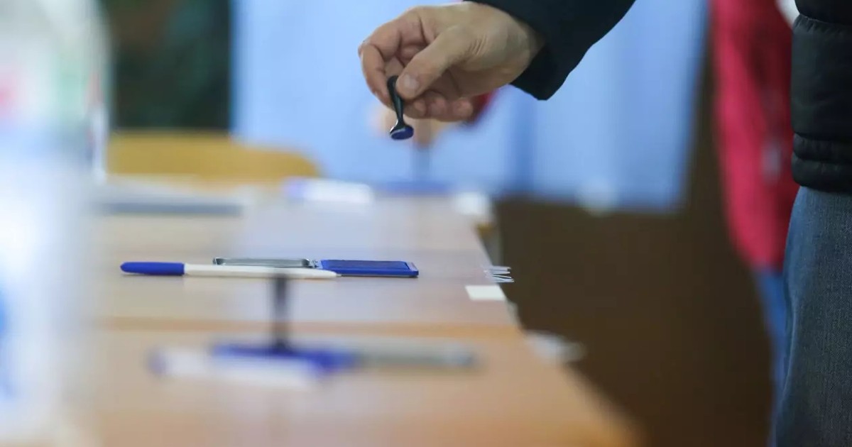 Imagine în care se vede mana unui barbat care predă stampila după ce a votat