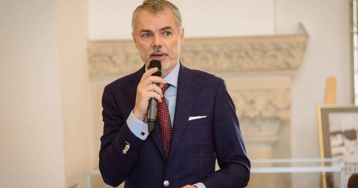 Un domn imbracat in costum vorbeste la telefon. Dr. Mihai Craiu pediatru despre rujeola si vaccinarea impotriva rujeolei