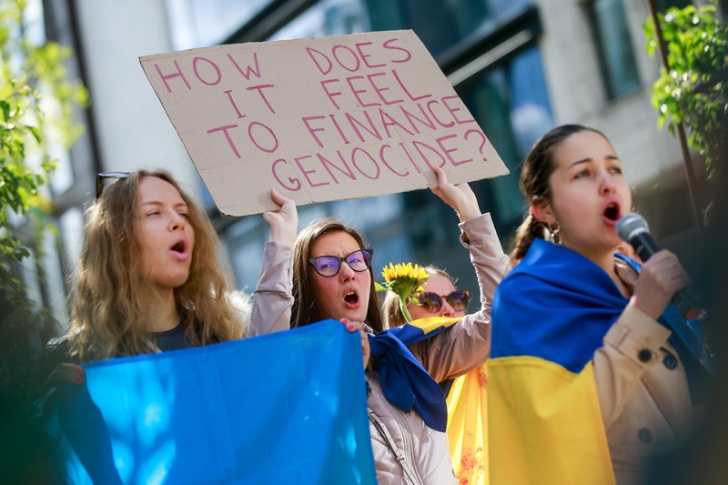 „Cum vă simțiți când finanțați genocidul”, unul dintre mesajele afișate de protestatari. | Foto: EPA