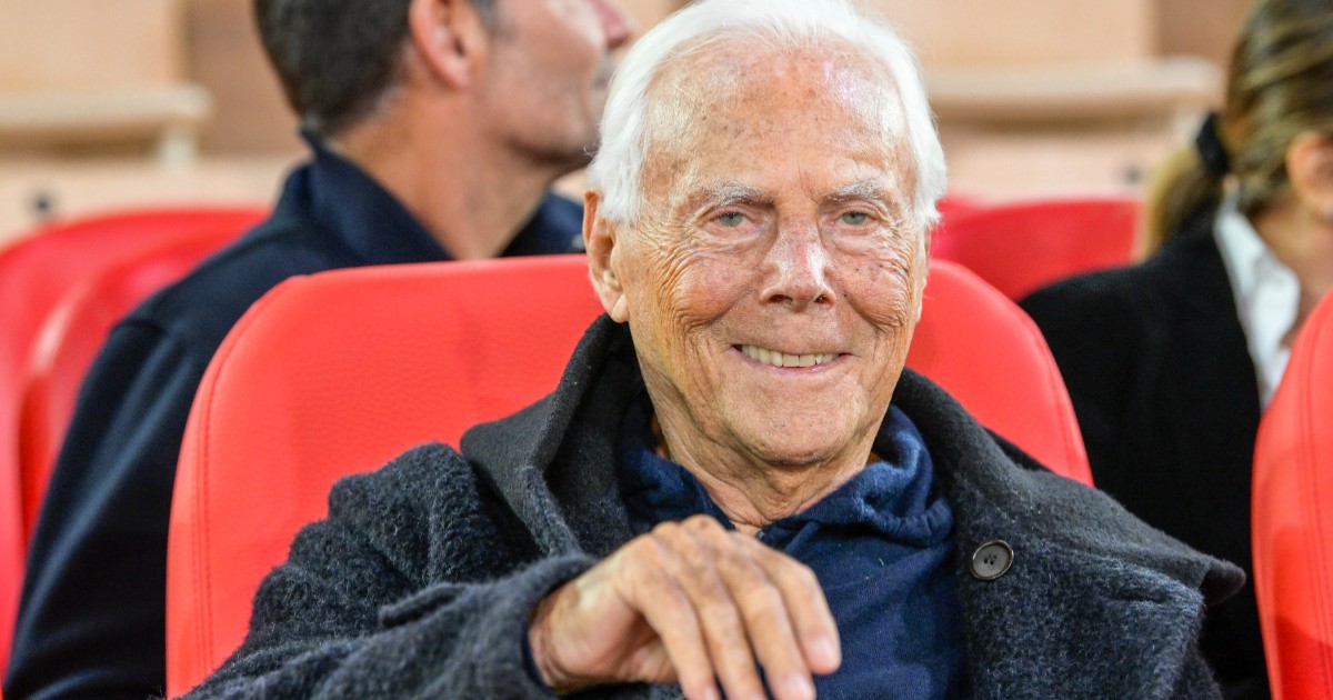 Giorgio Armani așezat pe un scaun roșu