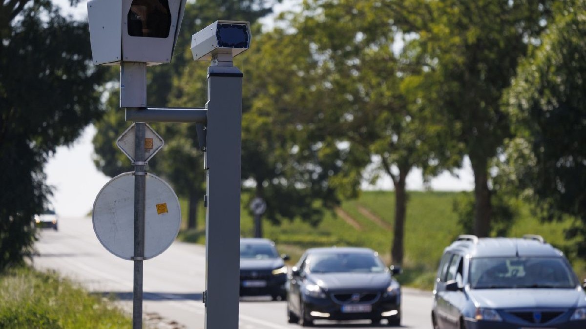 Imaginea ilustrativă prezintă un radar de viteză și trei mașini care circulă pe șosea
