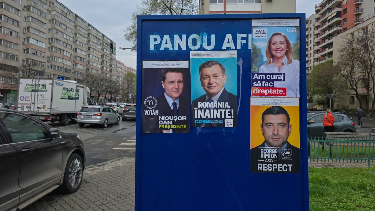 Panou pe care sunt lipite mai multe afise electorale cu Nicușor Dan, Crin Antonescu, Elena Lasconi și George Simion, în București.