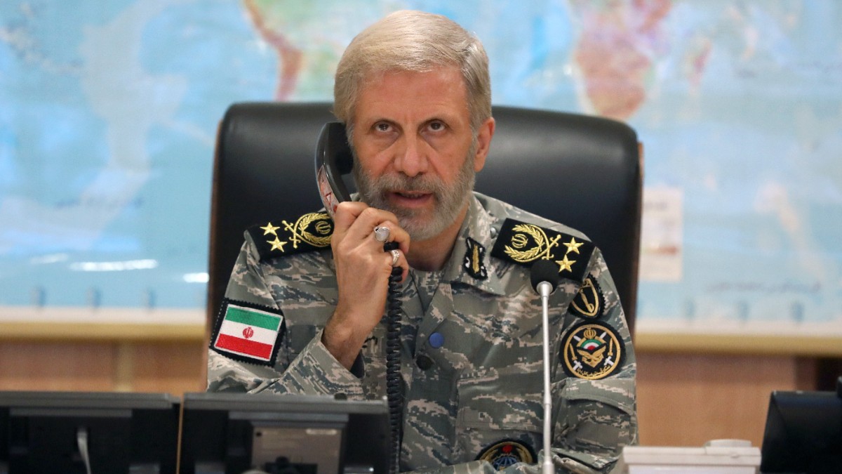 Imaginea îl prezintă pe generalul iranian Amir Hatami îmbrăcat în uniformă militară de camuflaj, vorbind la receptorul unui telefon fix în fața hărții lumii.