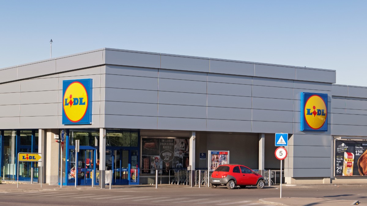 Un supermarket Lidl din România, o mașina roșie este parcată la intrare