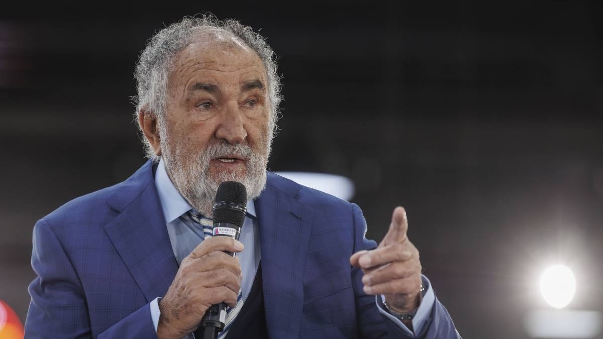ion tiriac imbracat intr-un sacou albastru in timpul unei conferinte vorbind la un microfon