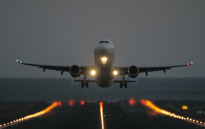 Un avion care aterizează pe seară.