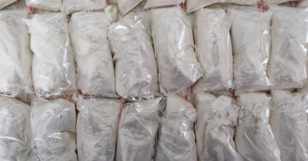 Un număr mare de pachete transparente umplute cu pulbere albă care este cocaină