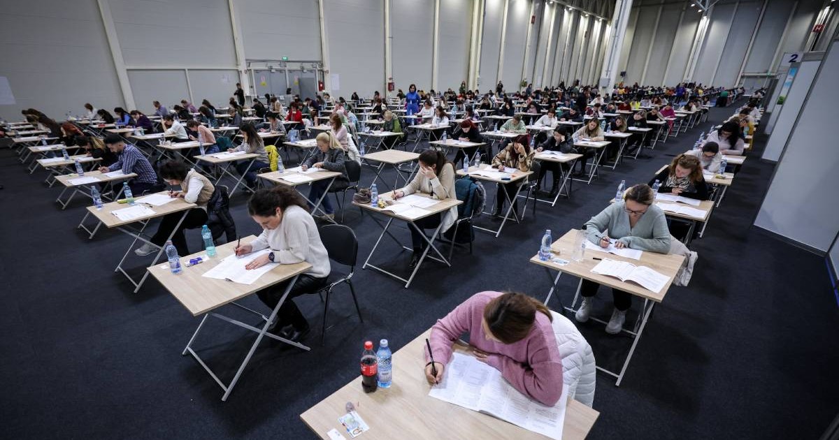 Mai mulți studenți de la UMF Carol Davila în timpul examenului de admitere la rezidențiat, aceștia rezolvă problemele în timp ce stau singuri în bănci, la distanță unii față de ceilalți