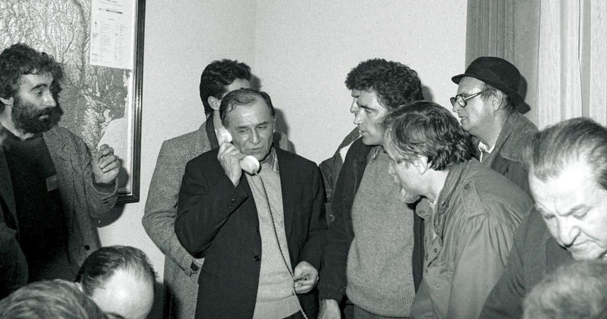 Ion Iliescu vorbind la telefon in sediul fostului Comitet Central al PCR, actualmente sediul MAI, pe 22 decembrie 1989. In stanga imaginii apare Adrian Sarbu, viitorul proprietar al PRO TV. Foto: Agerpres