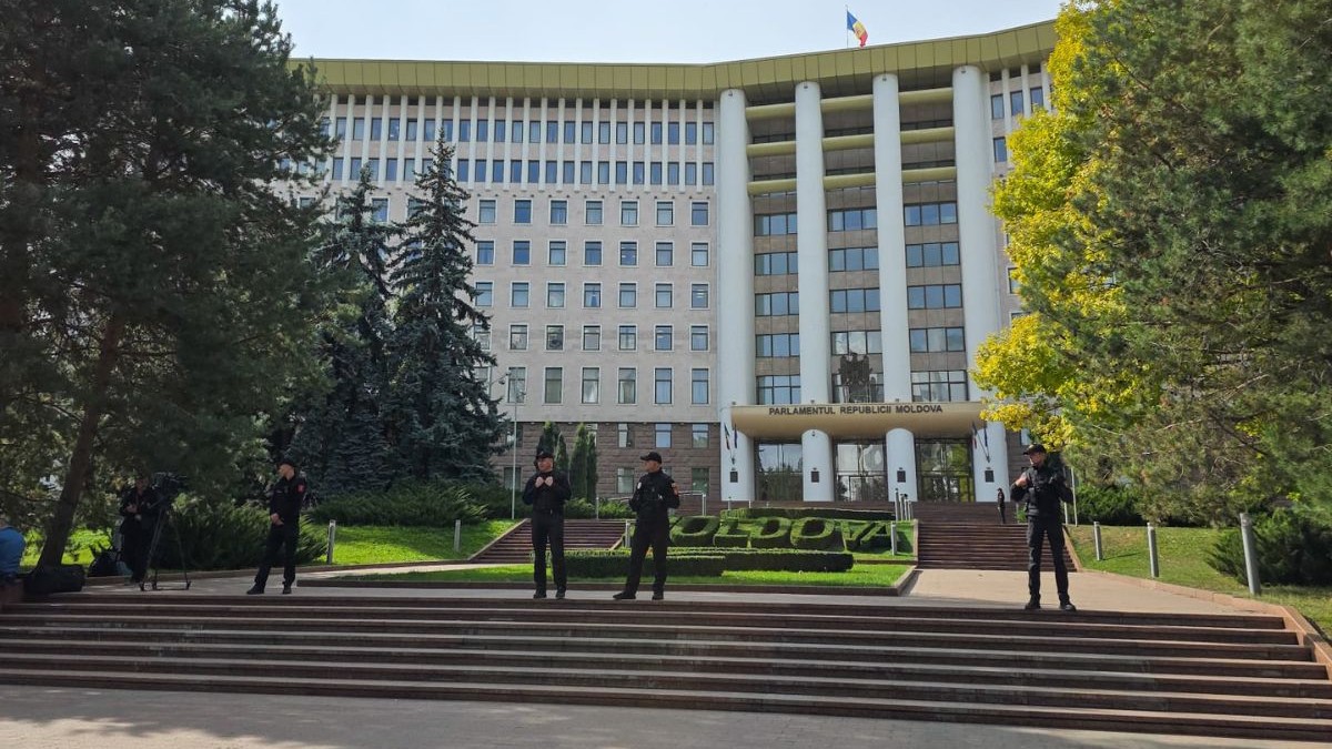 Clădirea parlamentului din Republica Moldova, înconjurată de patru jandarmi, care stau pe scările din fața clădirii. în spatele lor se vede un gard viu aranjat în forma literelor care formează cuvântul „Moldova”, Chișinău, 29 septembrie 2025