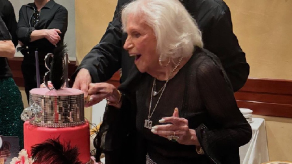 Carole Roth suflă în lumânările de pe tortul pe care l-a primit când a făcut 103 ani