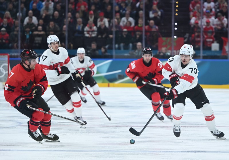Canadianul Devon Toews (nr. 7), în duel cu elvețianul Sandro Schimd. Foto: Imago