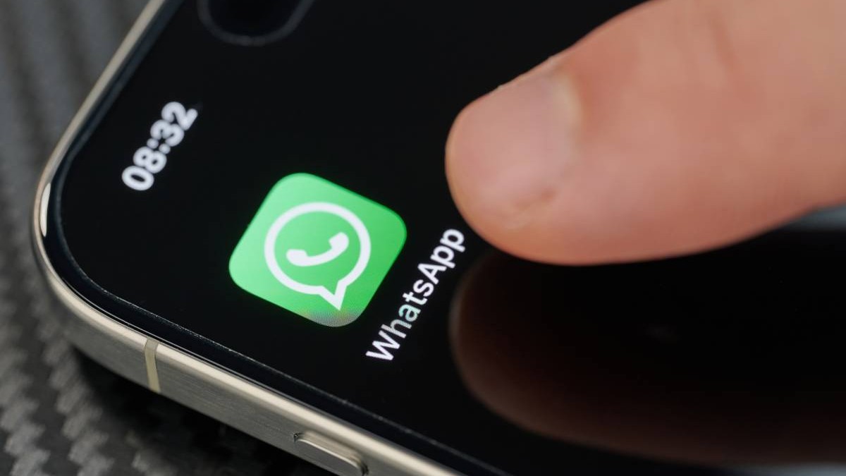 O persoană care apasă cu degetul pe ecranul telefonului și încearcă să intre pe WhatsApp