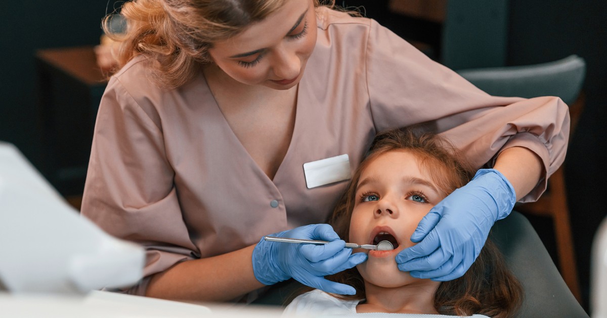 o fetita sata pe scaunul stomatologic cu gura cascata si un medic stomatolog lucreaza. Moartea fetiței de 2 ani de la clinica stomatologică din Sectorul 3.
