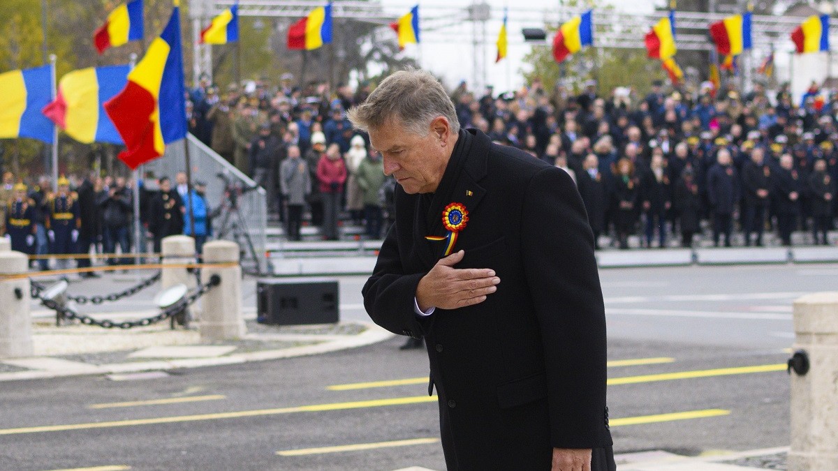 Președintele Klaus Iohannis, cu mâna dreaptă la piept, în fața unui grup de militari