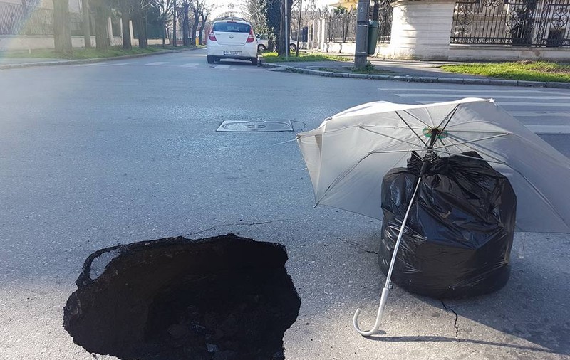 UPDATE: Un crater pe o stradă din centrul Timișoarei, semnalizat cu o umbrelă și un sac de gunoi. Scena, pozată de un consilier județean/ FOTO