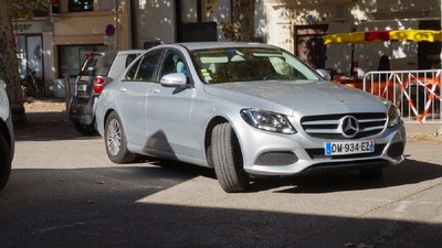 O mașină argintie, marca Mercedes, este cu roțile din față virate