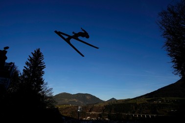 Săritorul Michael Hayboeck din Austria se ridică în aer în a patra etapă a celei de-a 71-a ediții a turneului de sărituri cu schiurile Four Hills din Bischofshofen, Austria - vineri, 6 ianuarie 2023. Munții de pe fundal nu au nici urmă de zăpadă | Foto: Profimedia Images