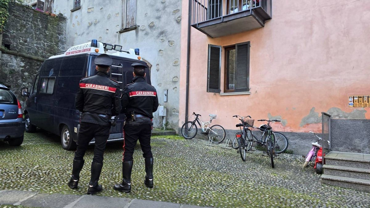 Doi carabinieri stau în curtea unei case