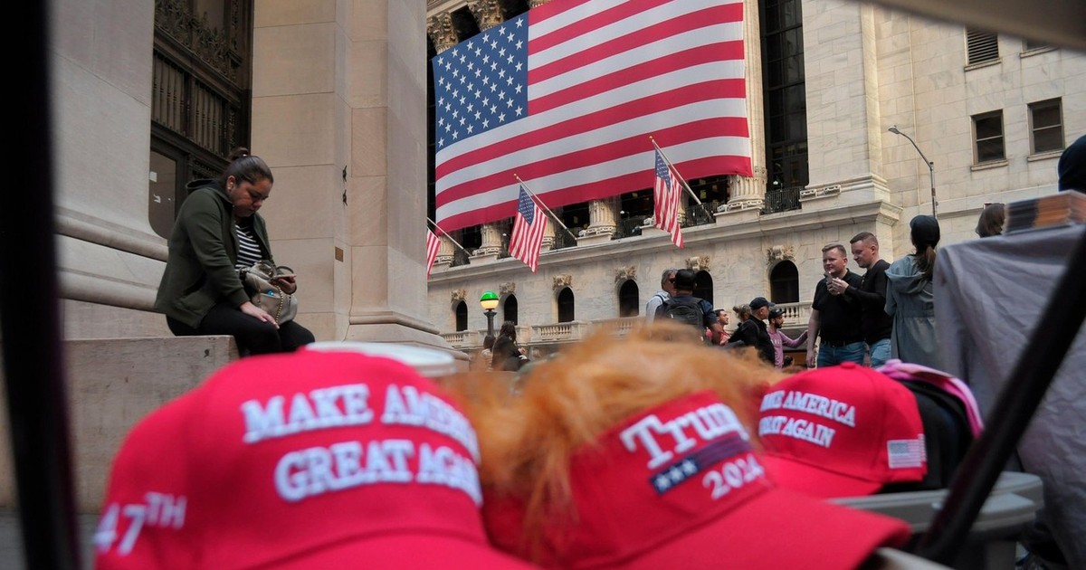 Șepci cu sloganul lui Donald Trump: „Make America Great Again”, vândute la New York, în spate se vede steagul SUA