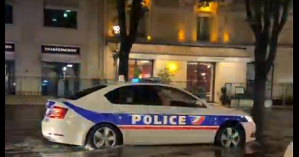 O mașină de poliție merge pe o stradă inundată de apă din Paris, în urma unei furtuni violente, 25 iunie 2025