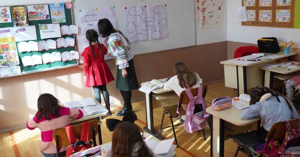 O profesoară este în clasă cu mai mulți elevi