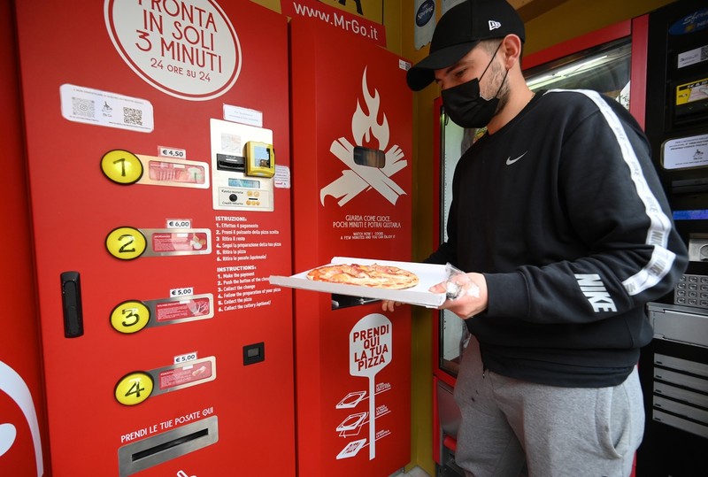 Unii clienți încearcă din curiozitate pizza de la automatul „Mr. Go” | Foto: Profimedia