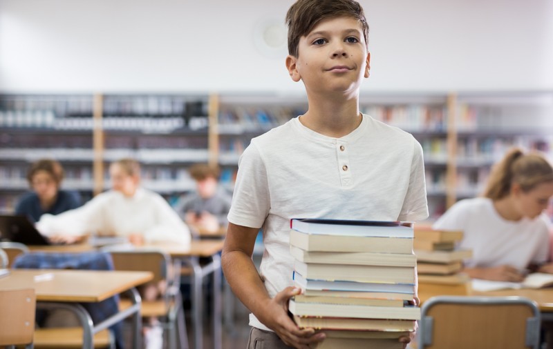 An de an, ghiozdanele elevilor devin din ce în ce mai încărcate cu manuale școlare și auxiliare la aproape fiecare disciplină. Foto: Shutterstock