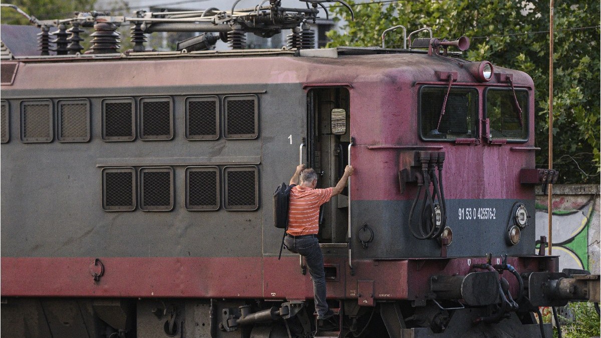 Un barbat urca intr-o locomotova in apropierea Garii Basarab dupa un accident dintre o locomotiva si vagoanele unui tren de calatori, petrecut in timpul procesului de cuplare, in Bucuresti, vineri, 19 iulie 2024.