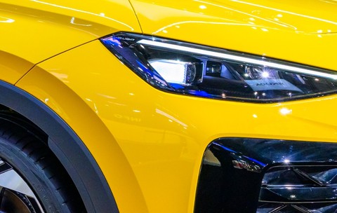 Imaginea prezintă de aproape farul cu LED-uri și o parte din grila frontală ale unui automobil de culoare galben strălucitor.