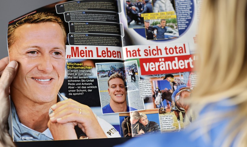epa10581740 A woman reads the edition of German weekly magazine Die Aktuelle with the cover announcing a fake interview with Michael Schumacher, in Berlin, Germany, 20 April 2023. A spokesperson for the Schumacher family announced to take legal actions against the magazine that runs their cover with a story with a picture of Schumacher and under the headline "Michael Schumacher, the first interview" which was generated by an artificial intelligence (AI) chatbot. Formula One legend Schumacher retreated from public life following a skiing accident in the French Alps in 2013 and his family has remained protective of his privacy. EPA-EFE/HANNIBAL HANSCHKE