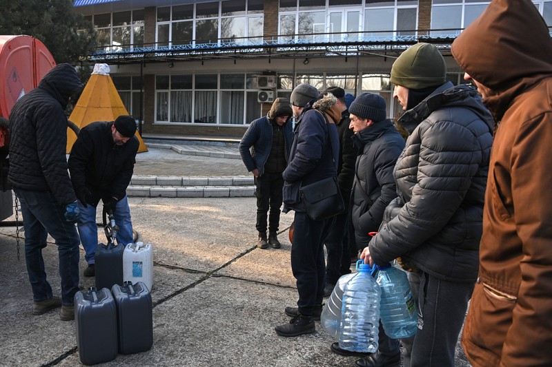 Oamenii stau la coadă pentru a primi benzină gratuită în Berdyansk, Ucraina. Foto: Profimedia