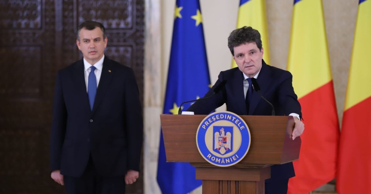 Președintele Nicușor Dan îmbrăcat cu un costum negru, la pupitrul de la Administrația Prezidențială, alături de Eugen Tomac, în stânga sa, îmbrăcat în costum negru, cămașă albă și cravată albastră, iar pe fundal steagurile României și Uniunii Europene