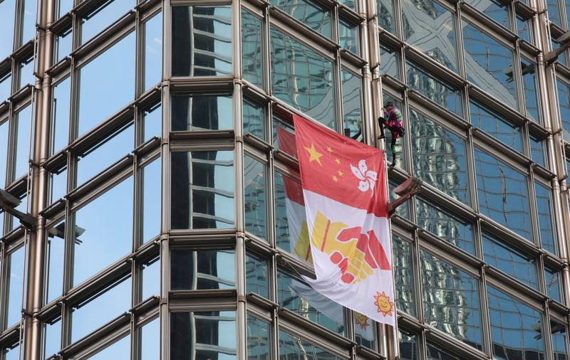 Un cățărător a escaladat un zgârie-nori din Hong Kong pentru a lansa un mesaj la pace cu China