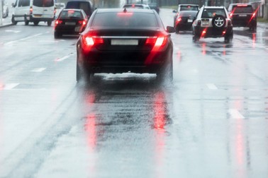 driving cars on a wet street with splashing water in motion blur. rainy road.