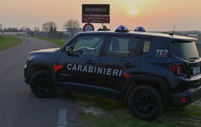 O mașină de teren a Carabinierilor italieni oprită pe marginea unui drum rural, lângă un indicator rutier pentru localitatea Occhiobello, la apus.