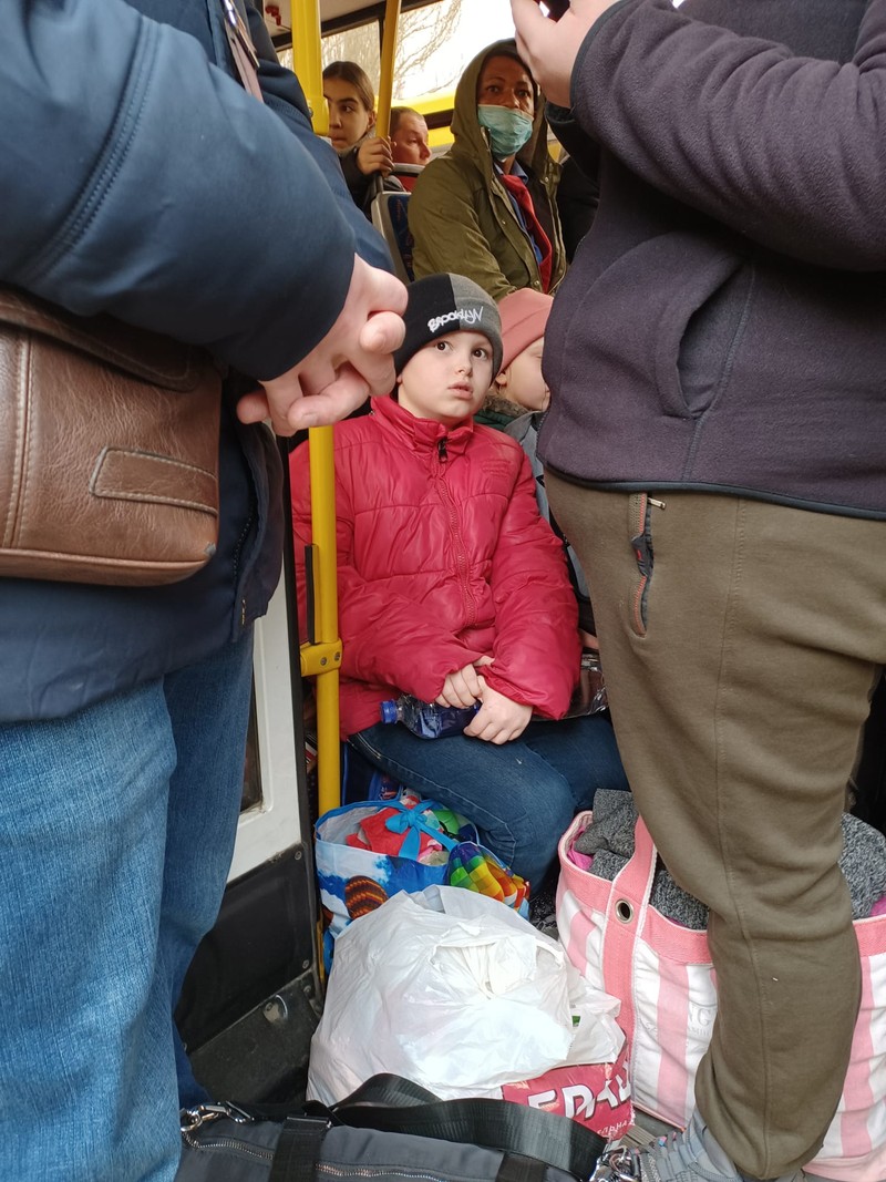 Un băiețel înghesuit într-un autobuz care pleacă din Mariupol spre Kiev