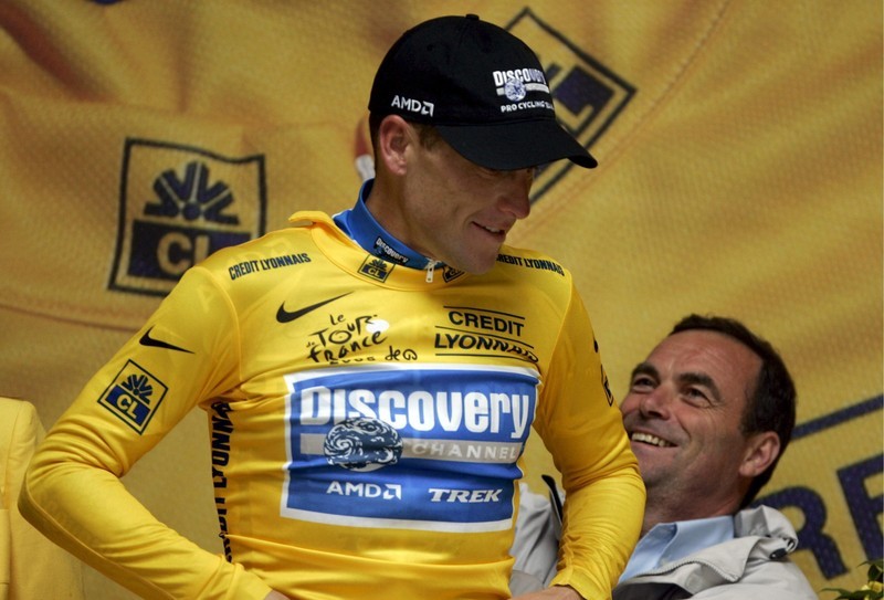 Hinault ajutând-ul pe americanul Lance Armstrong să îmbrace tricoul galben de lider al Turului Franței. Ulterior, Armstrong avea să recunoască că s-a dopat, iar performanțele sale au fost șterse din istoria sportului | Foto: EPA