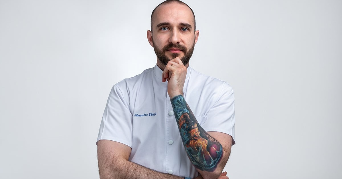 Ioan Stan îmbrăcat în halat de doctor cu mâna în bărbie.