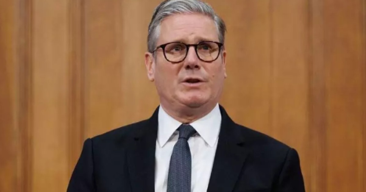 În imagine este ilustrat Keir Starmer, un bărbat îmbrăcat în costum negru, cămașă albă și cravată gri.