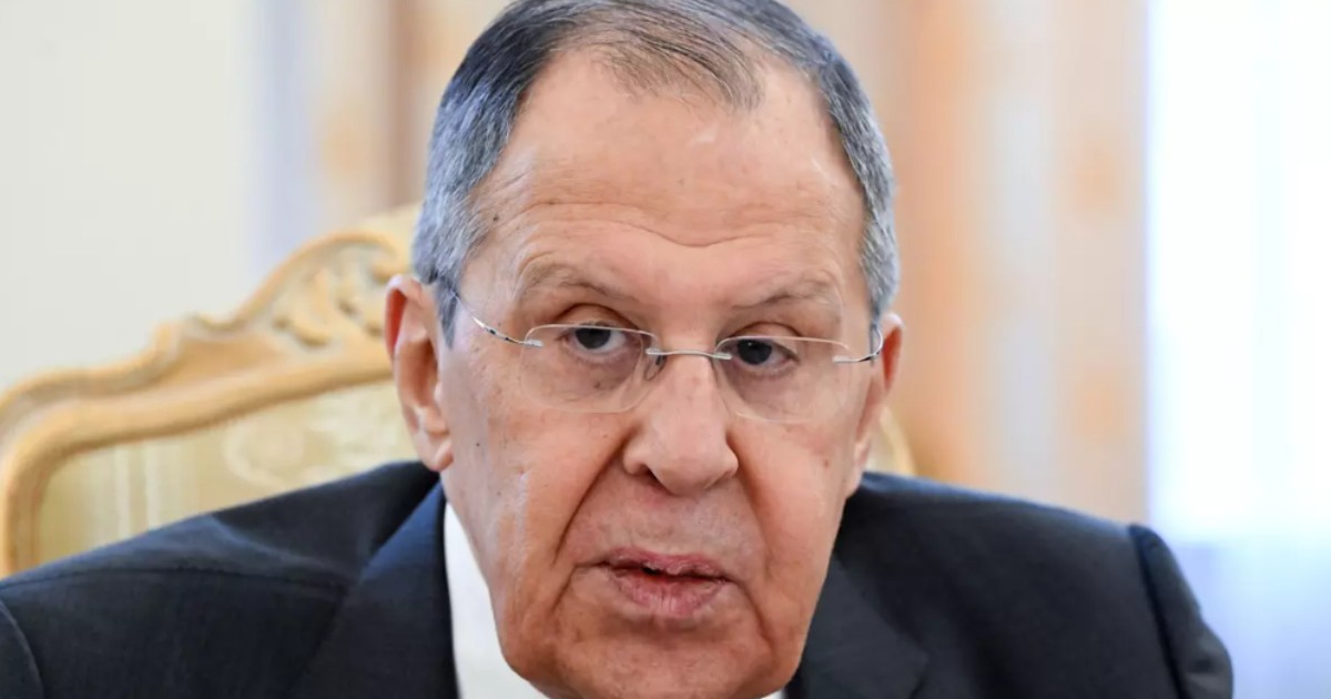 În imagine este ilustrat Serghei Lavrov, îmbrăcat cu costum negru, cămașă albă și poartă ochelari