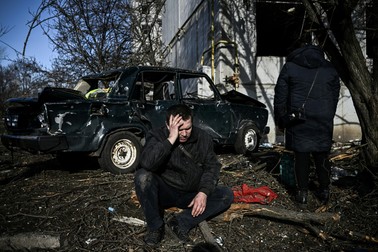 Un bărbat stă în fața clădirii sale distruse după bombardamentele asupra orașului Chuguiv, din estul Ucrainei, pe 24 februarie 2022, în timp ce forțele armate ruse încearcă să invadeze Ucraina din mai multe direcții Foto: Profimedia