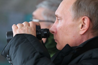 Președintele rus Vladimir Putin urmărește cu un binoclu exercițiile militare de la Marea Neagră din martie 2013 | Foto: EPA
