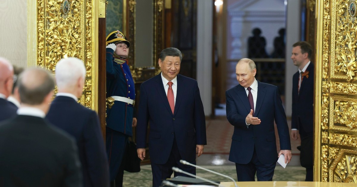 Xi Jinping, în stânga imaginii, condus de Vladimir Putin la Kremlin, în timp ce oficialii ruși prezenți în sală stau în picioare în fața sa Foto: Profimedia