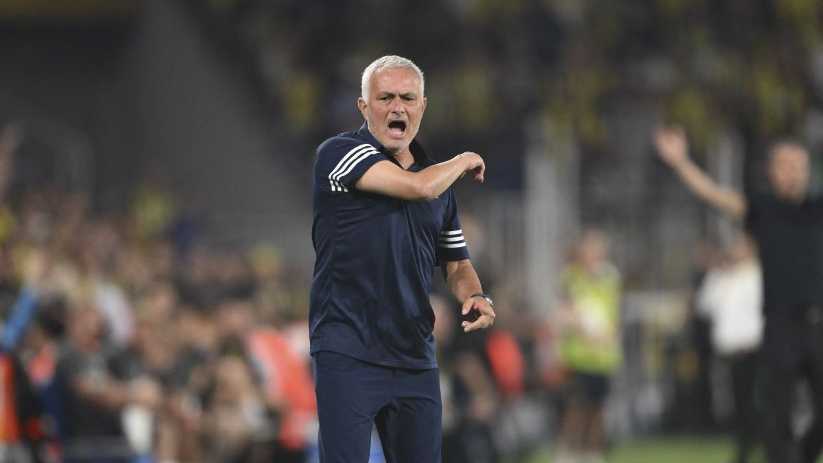 Jose Mournho, înbrăcat într-un tricou negru cu insrții albe, gesticulează cu mâna dreaptă, în timp ce se răstește la jucători de pe marginea terenului, august 2025