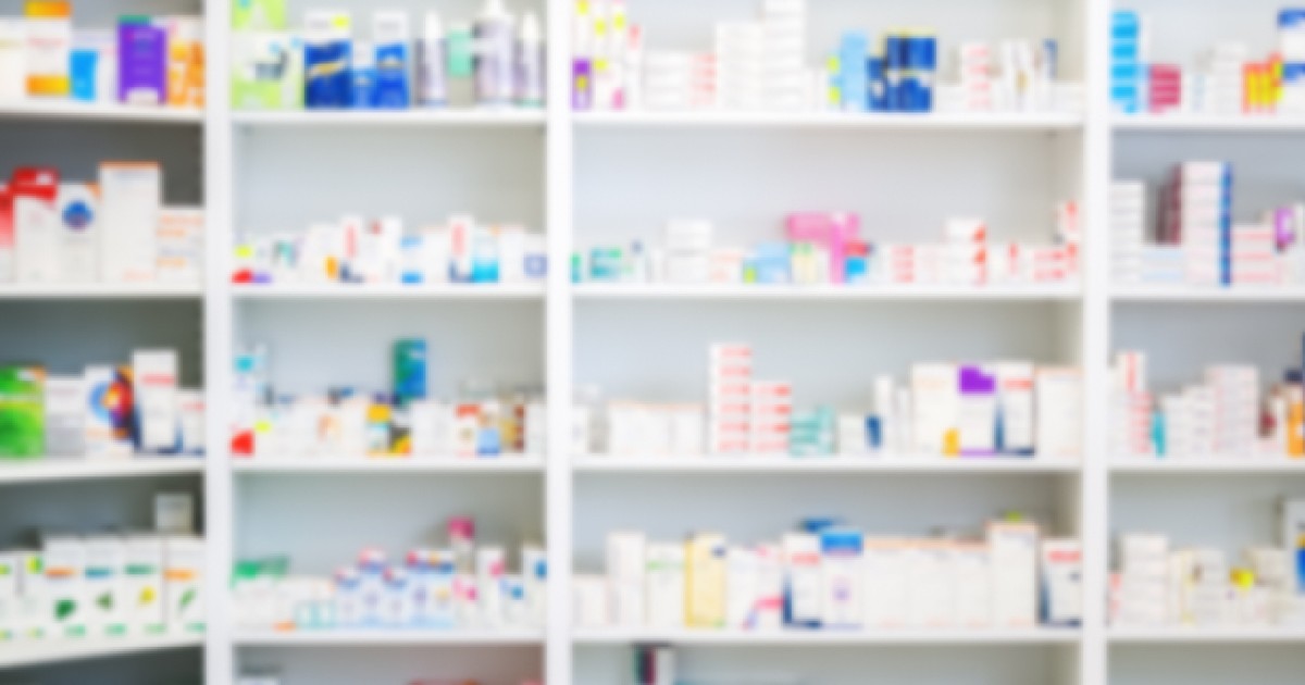 Medicamente aranjate în rafturi la farmacie
