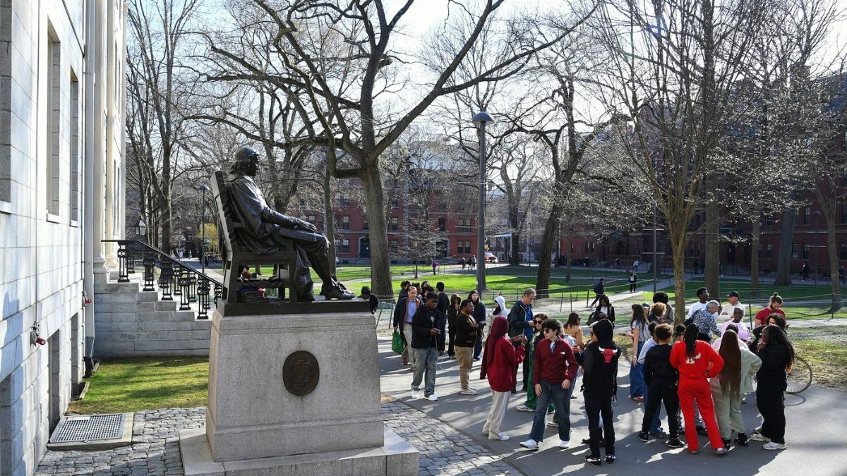 Oamenii adunați în jurul statuii lui John Harvard în Harvard Yard pe 15 aprilie 2025, la Universitatea Harvard din Cambridge, MA.